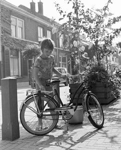 884240 Afbeelding van een jongetje dat zijn fiets op slot zet, op de de Wagendwarsstraat te Utrecht.